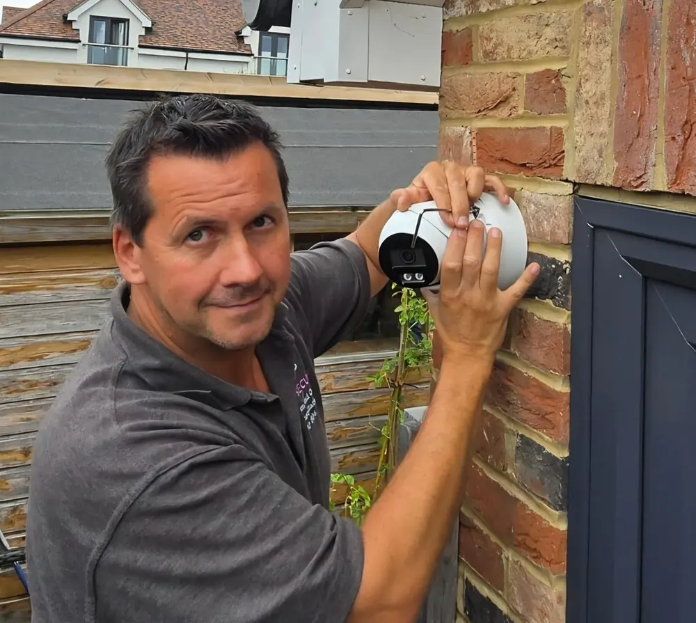 Kris Hill of ITD Secure fitting and aligning a CCTV camera on the brickwork of a Kent property